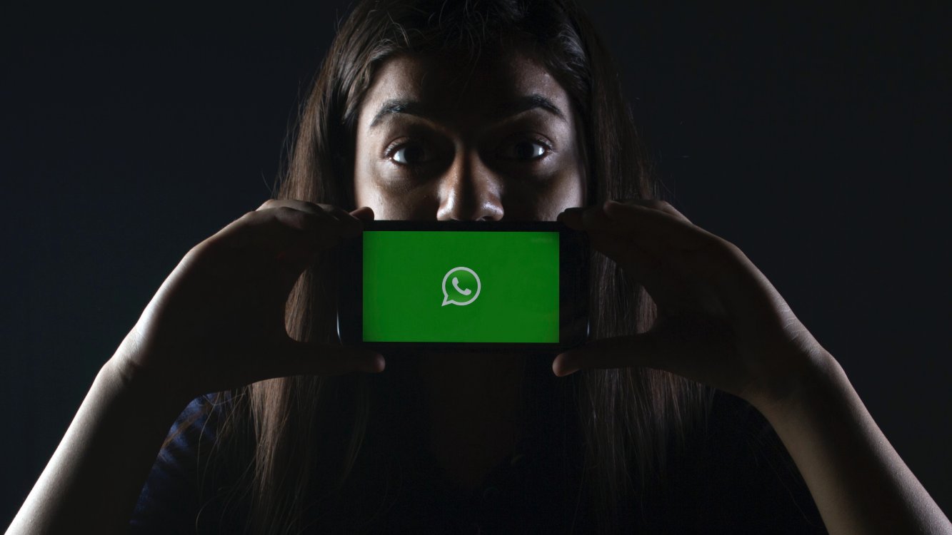 Mulher com o aplicativo WhatsApp no celular.