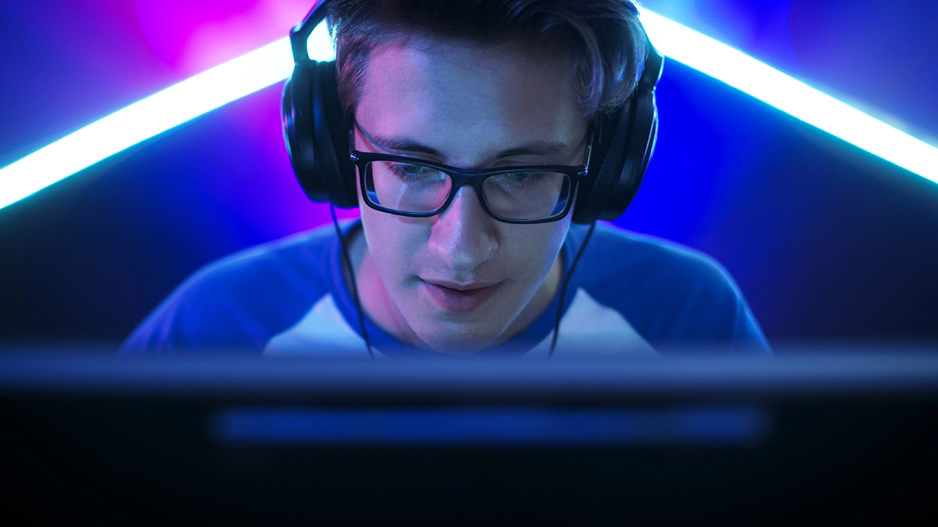 Homem com a face de frente para a tela do computador.