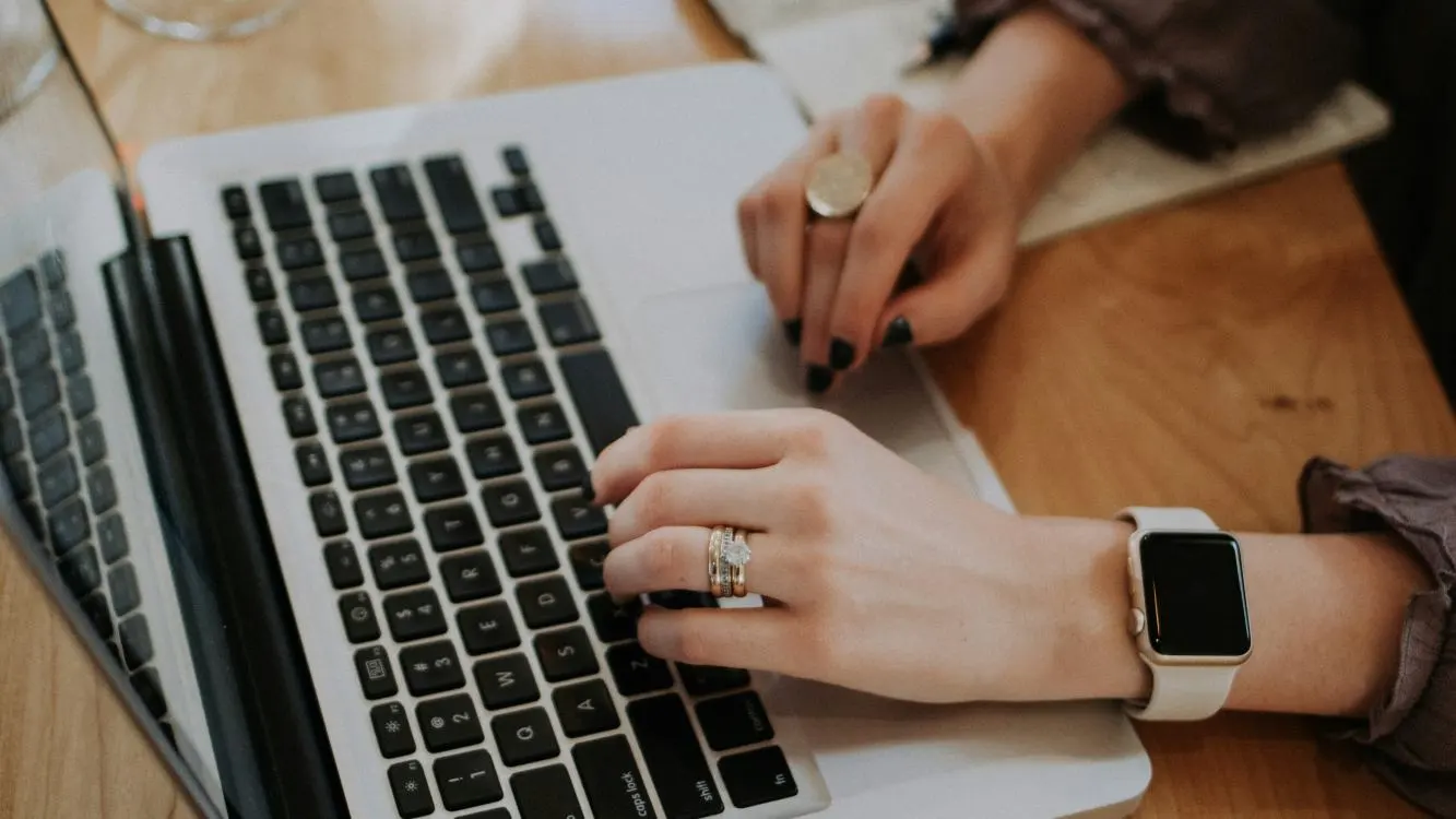 Mãos femininas digitando em um notebook