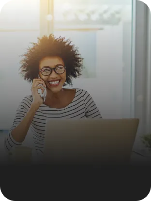 Enquanto trabalha de casa, mulher usa o celular e o laptop conectada à internet Oi Fibra