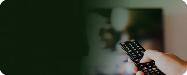 Pessoa com controle remoto na mão assiste a filmes e séries online em streaming