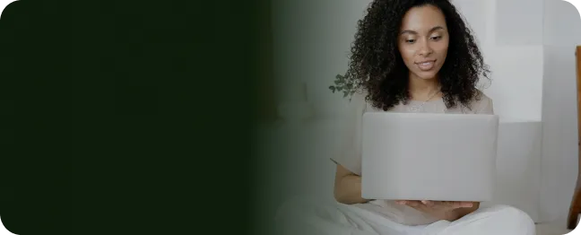 Sentada no chão, cliente da internet Oi Fibra usa seu laptop