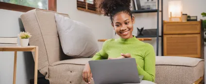 Sentada em sua sala, mulher faz reunião online em um laptop conectado à Oi Fibra