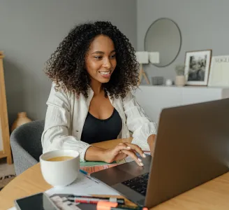 Em home office, mulher trabalha em laptop na mesa da sala