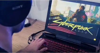 Homem em seu notebook joga Cyberpunk 2077