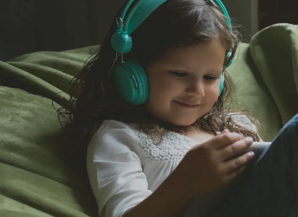 criança sorrindo olhando para o tablet