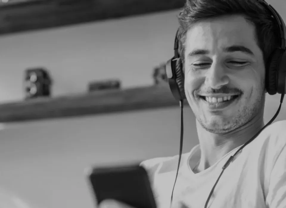 Homem sorrindo olhando o celular