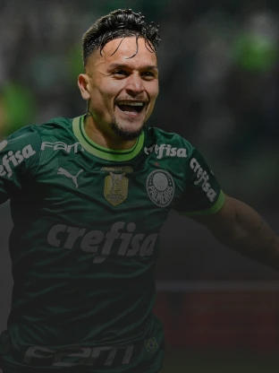A imagem mostra um jogador do Palmeiras comemorando