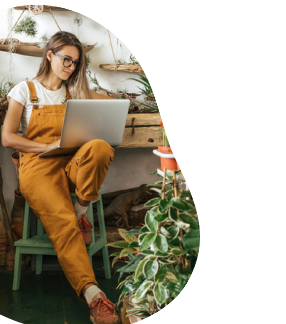 Mulher no jardim usa o notebook e navega com internet fibra ótica