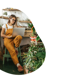 Mulher no jardim usa o notebook e navega com internet fibra ótica