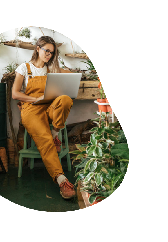 Mulher no jardim usa o notebook e navega com internet fibra ótica
