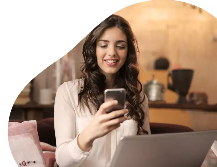Mulher teleagente olhando para o celular após fechar mais uma venda de Oi Fibra