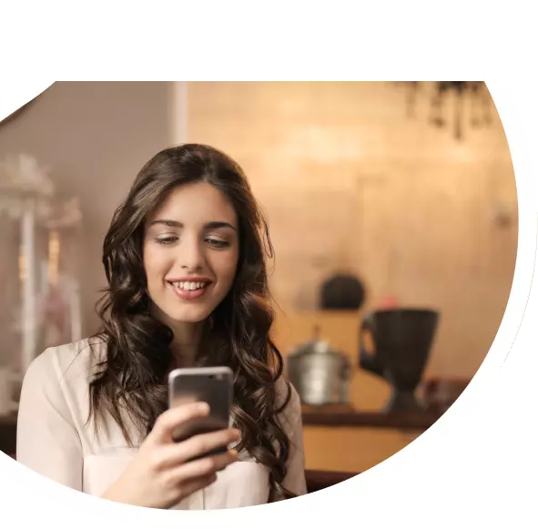 Mulher teleagente olhando para o celular após fechar mais uma venda de Oi Fibra