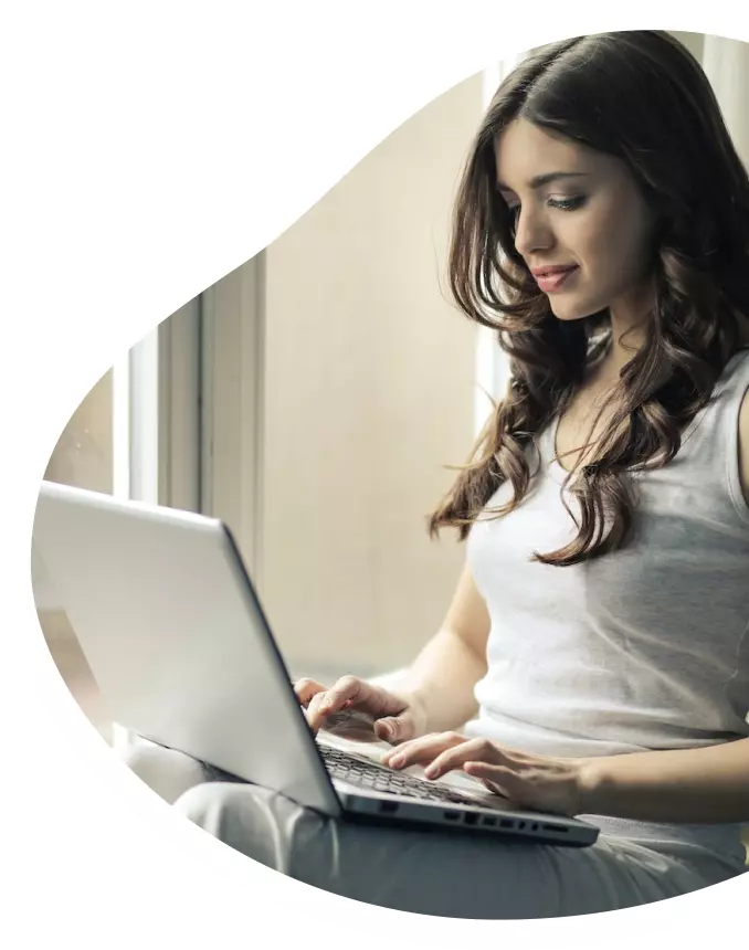 Mulher preenchendo no notebook o formulário de parceria Oi Fibra